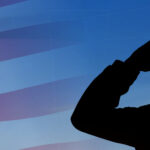 A silhouette saluting the American flag