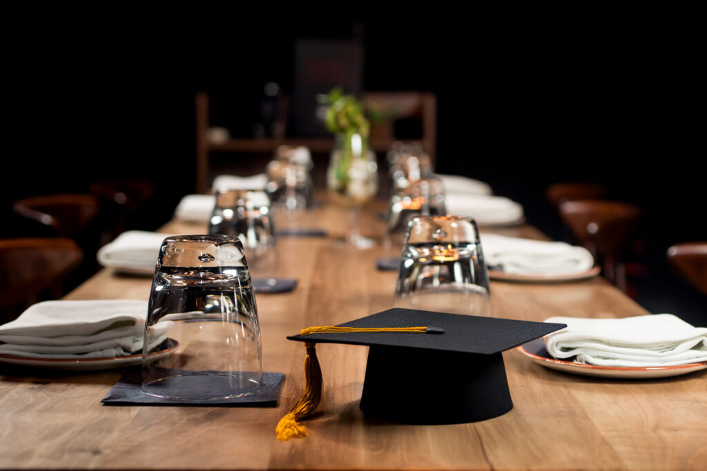 A graduation cap on a table set for a party at Bertucci's
