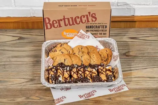 A catering tray of mini cannoli and cookies