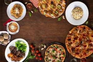 Pizza and entrées on a table from above